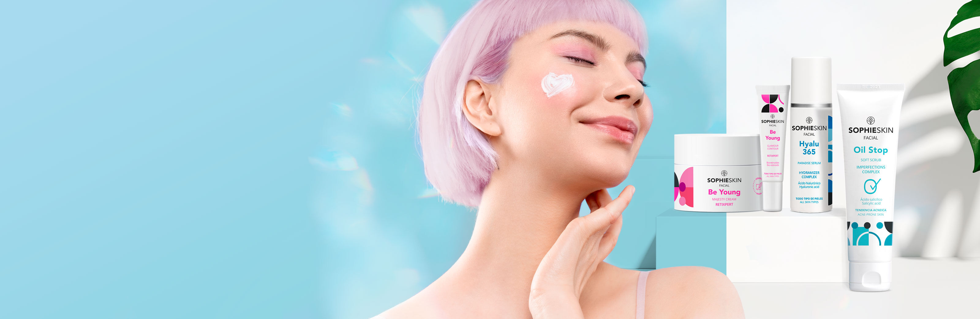 Imagen chica con pelo rosa sonriendo, ojos cerrados y crema en el pómulo, al lado cuatro productos Sophieskin